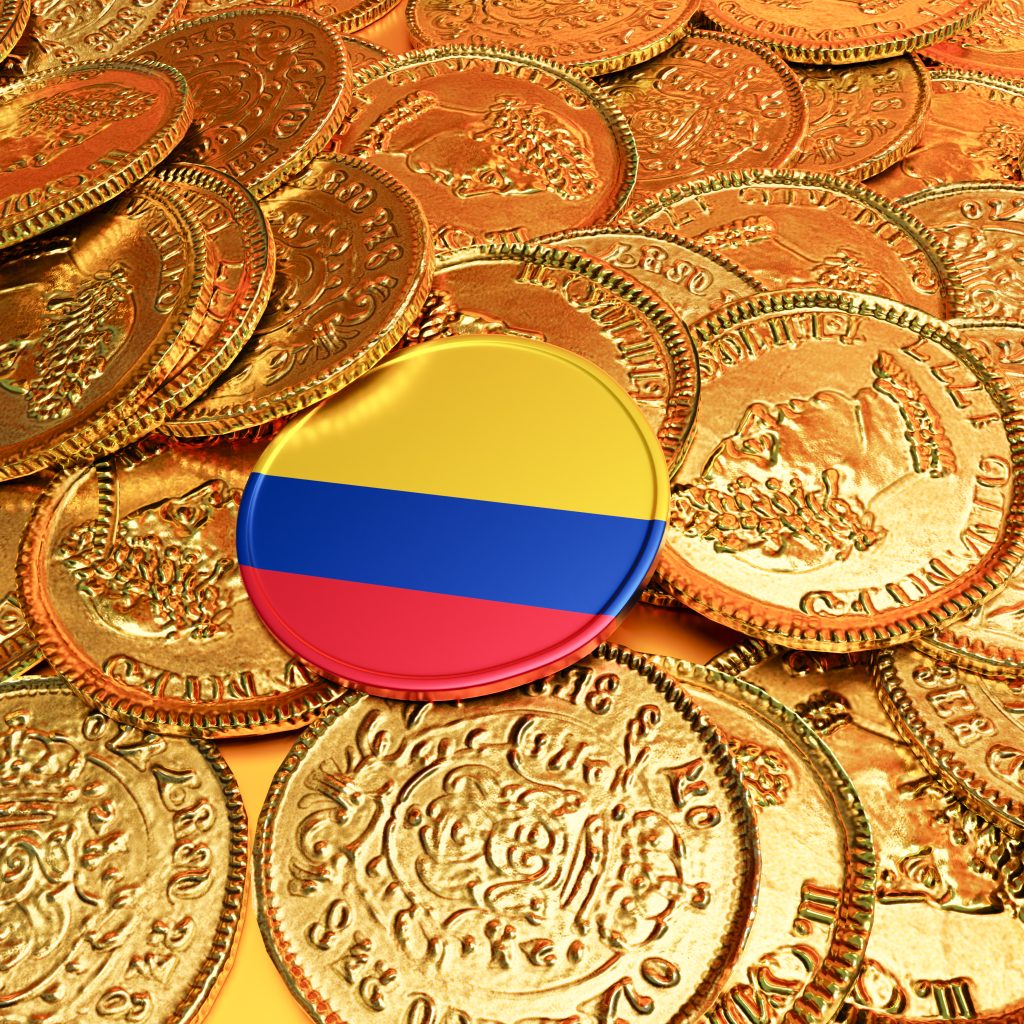Moneda y una moneda con la bandera de colombia